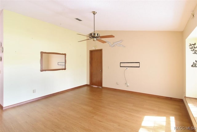 empty room with visible vents, light wood-style floors, vaulted ceiling, ceiling fan, and baseboards