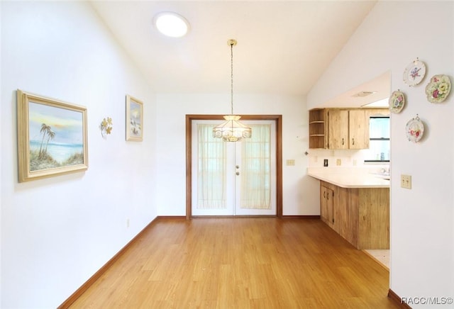 kitchen featuring open shelves, light wood-style floors, pendant lighting, and light countertops