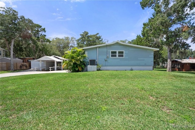 exterior space featuring a lawn and central AC unit