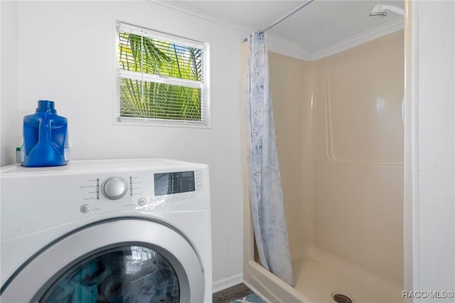 clothes washing area with washer / dryer and crown molding