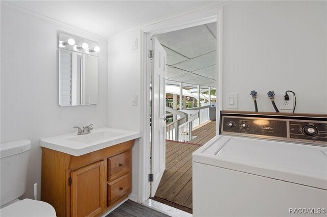 interior space featuring crown molding, dark hardwood / wood-style flooring, sink, and washer / clothes dryer