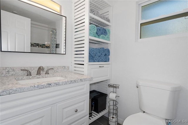 bathroom featuring a shower with curtain, vanity, and toilet