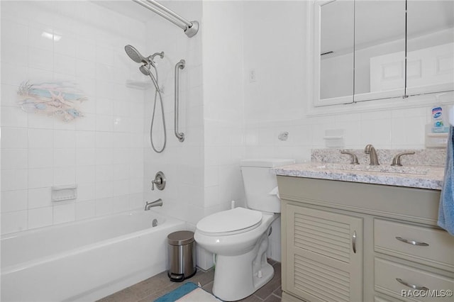 full bathroom featuring vanity, toilet, tile walls, and tiled shower / bath combo