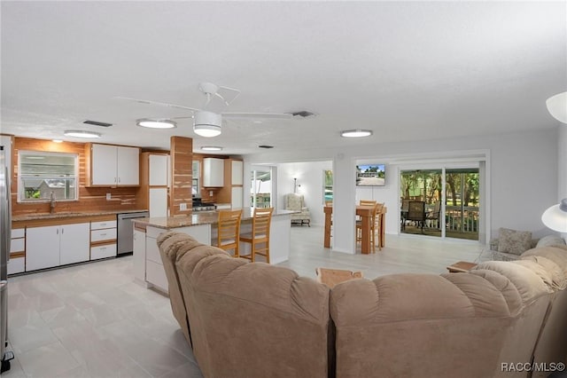 living room featuring ceiling fan and sink