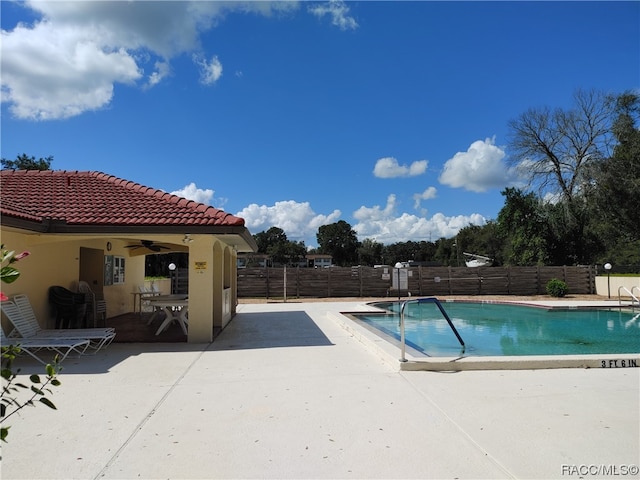 view of swimming pool featuring a patio and ceiling fan