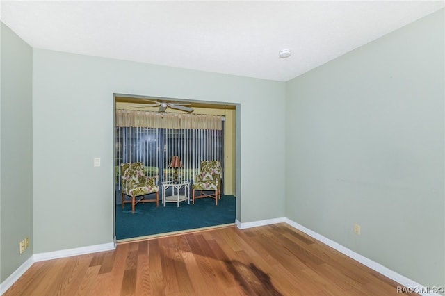 empty room with hardwood / wood-style floors and ceiling fan