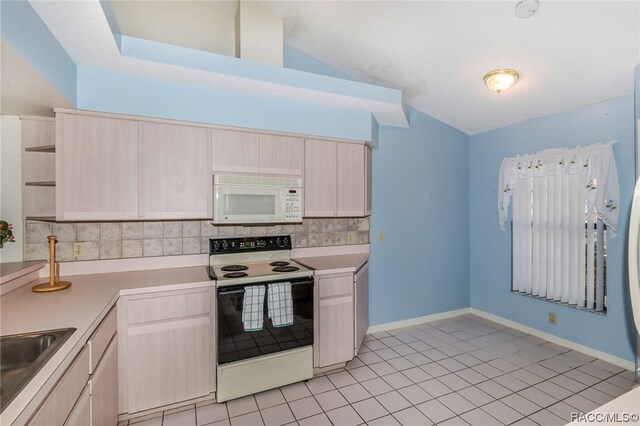 kitchen with light brown cabinetry, tasteful backsplash, white appliances, light tile patterned floors, and lofted ceiling