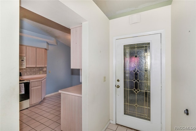 interior space featuring light tile patterned floors and vaulted ceiling