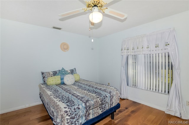 bedroom with ceiling fan and dark hardwood / wood-style flooring