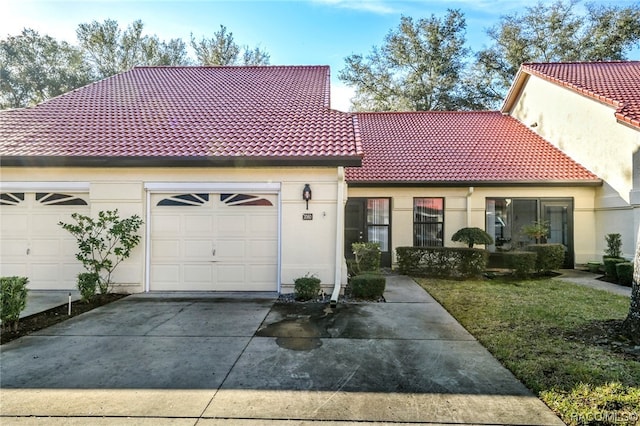 mediterranean / spanish-style home featuring a front yard and a garage