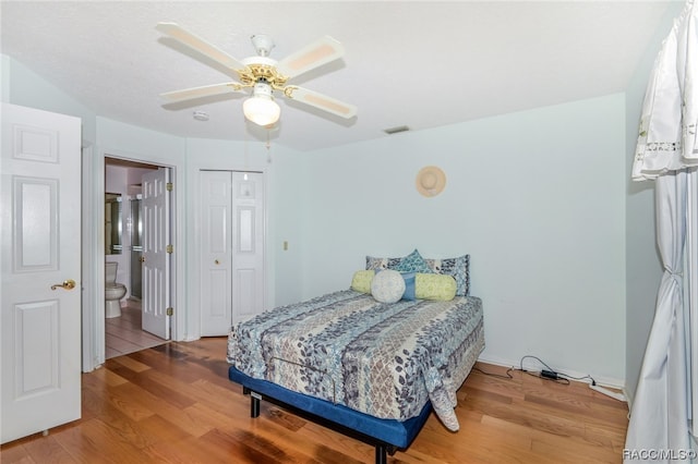 bedroom featuring a closet, connected bathroom, hardwood / wood-style flooring, and ceiling fan