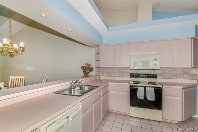 kitchen featuring backsplash, white appliances, sink, and vaulted ceiling