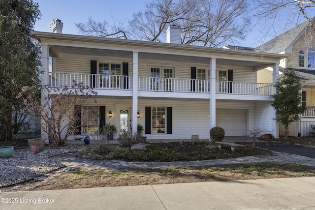 view of front of property featuring a garage and a balcony