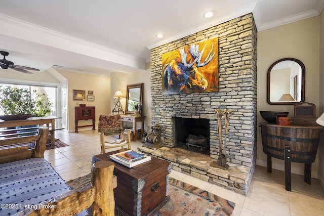 living room featuring crown molding, ceiling fan, a stone fireplace, and light tile patterned floors