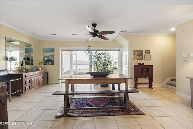 dining space with crown molding, light tile patterned floors, and ceiling fan