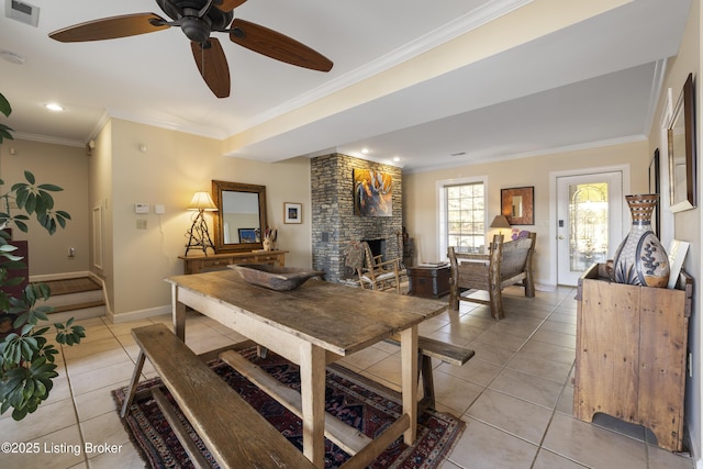 tiled dining space featuring crown molding and a large fireplace