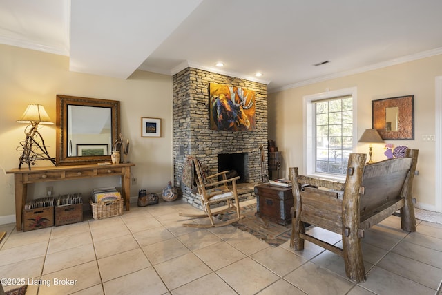 living area with ornamental molding, a stone fireplace, and light tile patterned floors