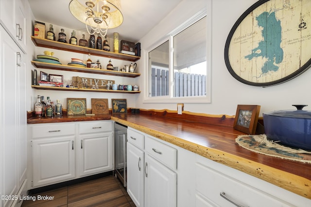 bar featuring wood counters, white cabinetry, wine cooler, hanging light fixtures, and a notable chandelier