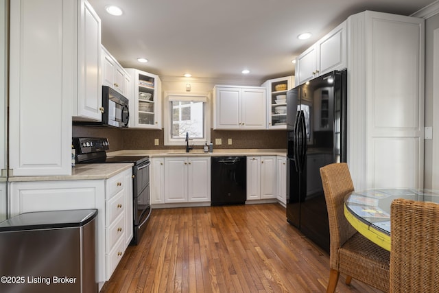 kitchen with white cabinetry, sink, dark hardwood / wood-style flooring, and black appliances