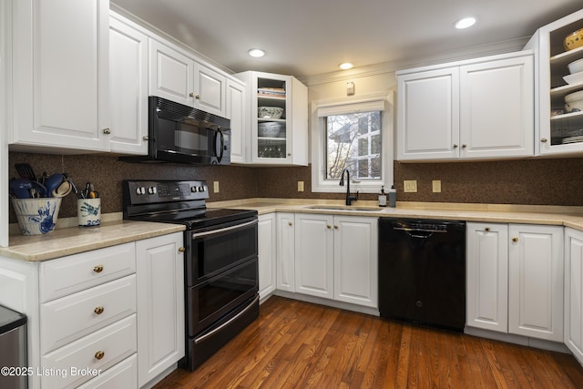 kitchen featuring sink, dark wood-type flooring, black appliances, and white cabinets