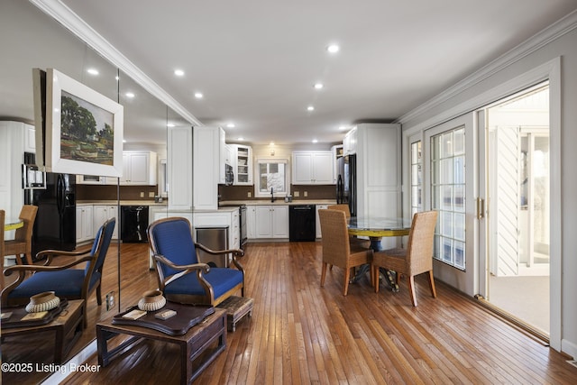 living room with crown molding, sink, light hardwood / wood-style flooring, and french doors