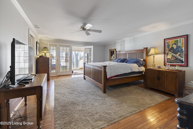 bedroom with hardwood / wood-style flooring, ornamental molding, and ceiling fan