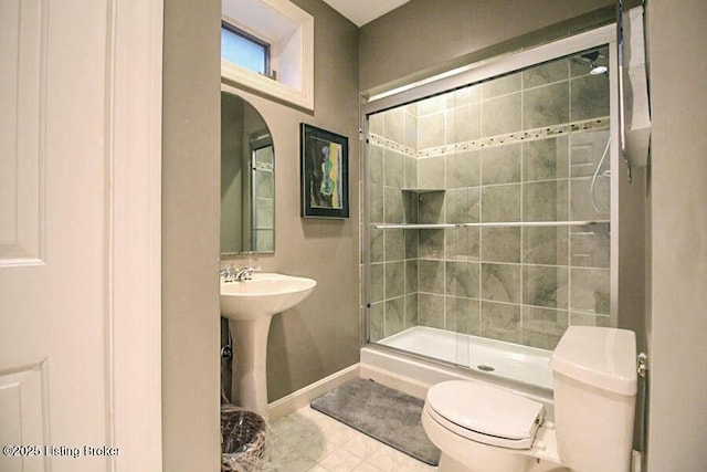 bathroom featuring toilet, sink, and a shower with shower door