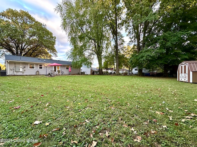 view of yard with central air condition unit and a storage shed