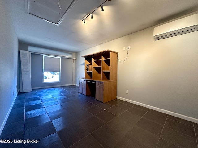 interior space featuring track lighting, dark tile patterned floors, and an AC wall unit