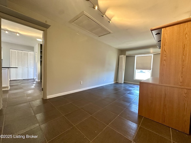 unfurnished room with dark tile patterned floors and track lighting