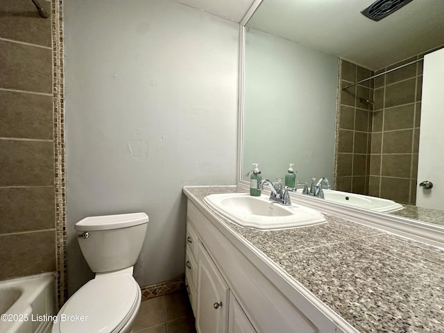 full bathroom with tile patterned flooring, tiled shower / bath, vanity, and toilet