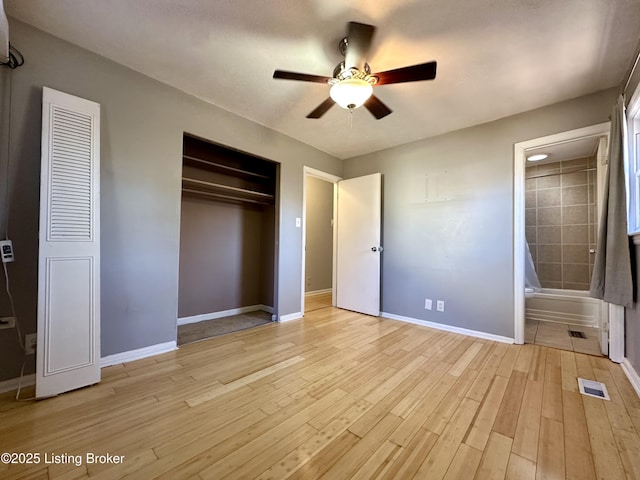 unfurnished bedroom featuring light hardwood / wood-style flooring, a closet, ceiling fan, and ensuite bathroom