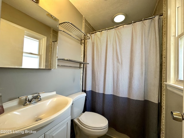 bathroom with vanity, a textured ceiling, and toilet