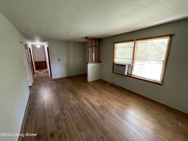 unfurnished living room featuring a textured ceiling, cooling unit, and wood-type flooring