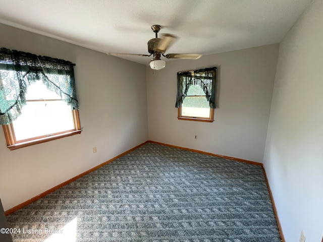 empty room with a textured ceiling, carpet flooring, and ceiling fan