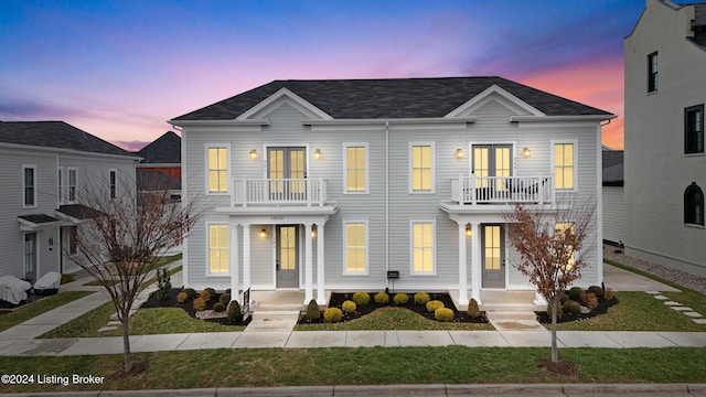 view of front facade with a balcony and french doors