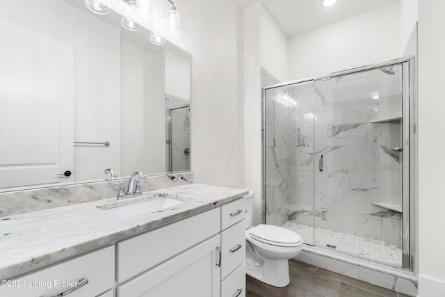 bathroom with vanity, wood-type flooring, an enclosed shower, and toilet