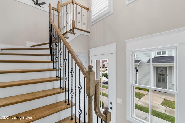 stairs featuring ceiling fan