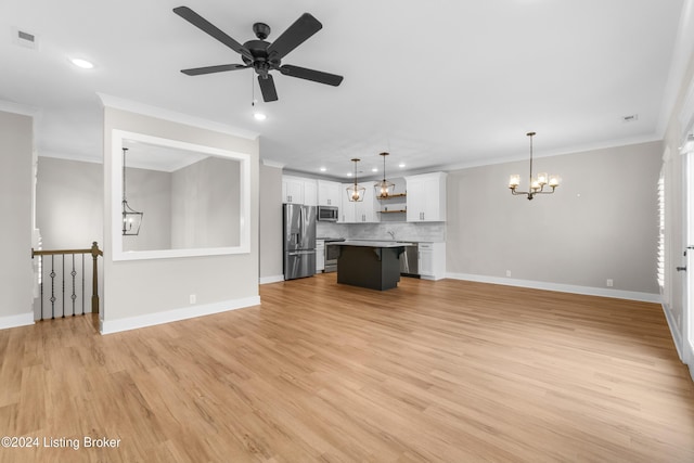 unfurnished living room featuring ceiling fan with notable chandelier, light wood-type flooring, ornamental molding, and sink