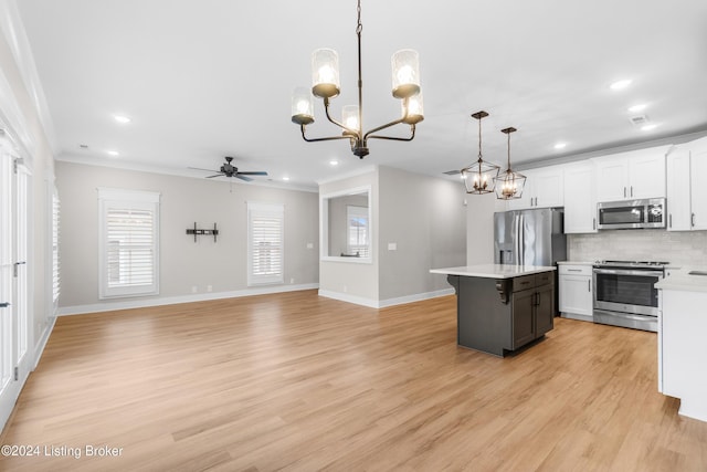 kitchen with white cabinets, decorative light fixtures, stainless steel appliances, and light hardwood / wood-style floors