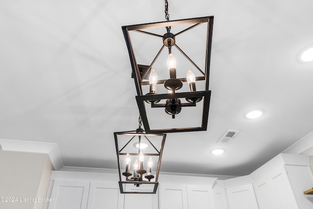 interior details featuring crown molding and an inviting chandelier