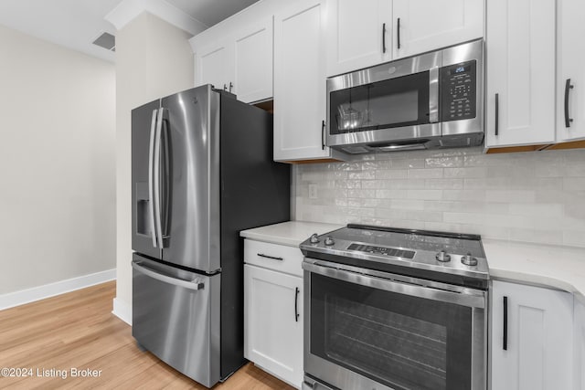 kitchen with decorative backsplash, appliances with stainless steel finishes, light stone countertops, light hardwood / wood-style flooring, and white cabinetry