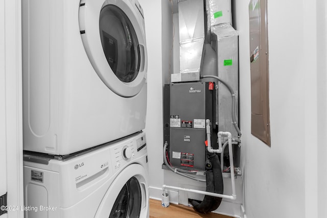 washroom featuring stacked washer and dryer and light hardwood / wood-style floors