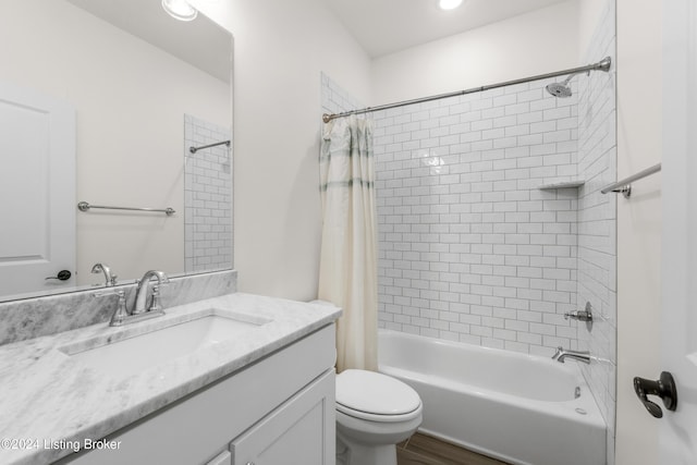 full bathroom with vanity, hardwood / wood-style flooring, toilet, and shower / bath combo with shower curtain