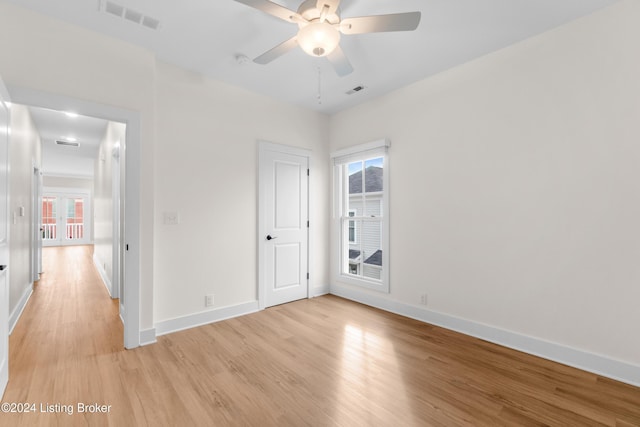 empty room featuring light hardwood / wood-style flooring, ceiling fan, and a healthy amount of sunlight