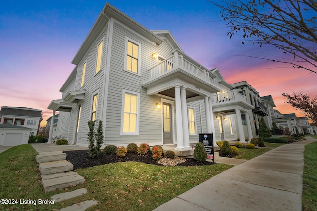 view of front of property featuring a balcony and a lawn