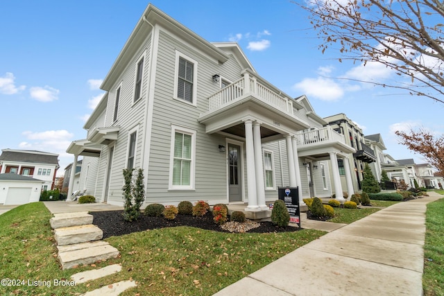 view of front of home featuring a balcony and a front yard