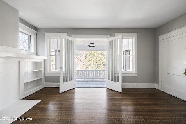 interior space with baseboards and wood finished floors