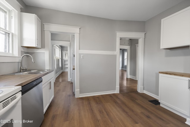 kitchen with a sink, baseboards, white cabinets, stainless steel dishwasher, and dark wood finished floors