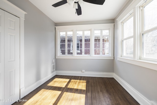 spare room with visible vents, dark wood finished floors, and baseboards